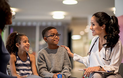 Mother with two kids attending a doctor's consultation together.